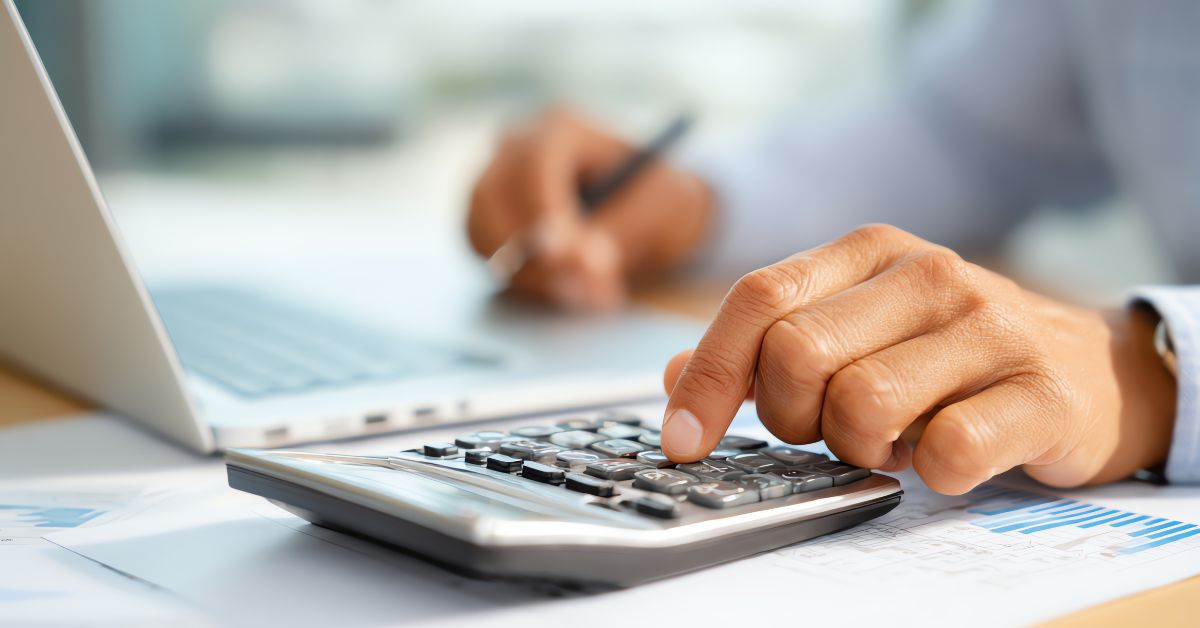 Payroll Image Decorative Payroll Image - Man Using a Calculator at a Laptop